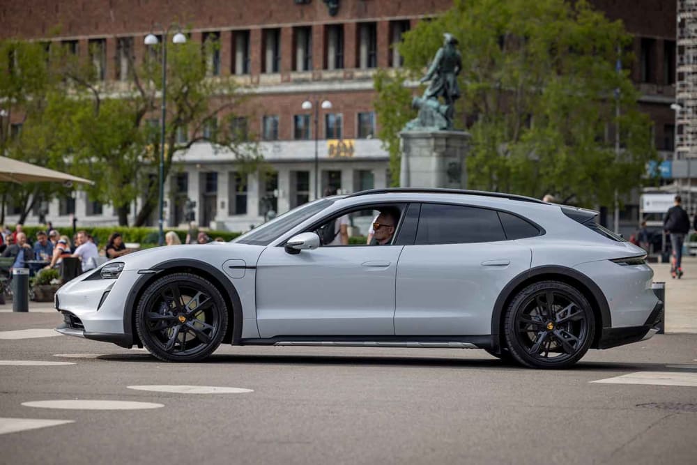 bildet viser en hvit Porsche Taycan 4 Cross Turismo sett fra siden.
